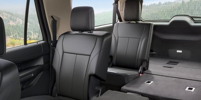 El espacioso interior de una Ford Expedition con las tres filas de asientos abatidas, mostrando un amplio espacio de carga.