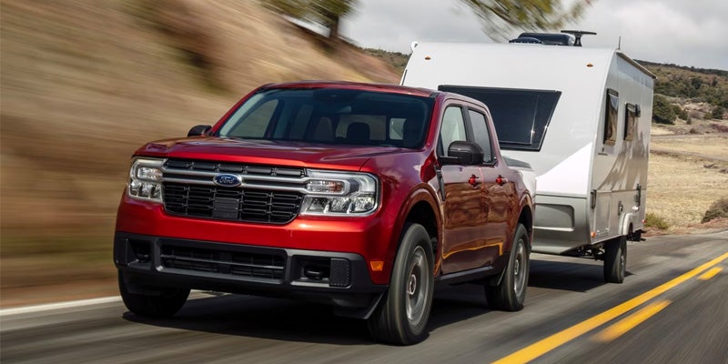 Red pickup truck towing white travel trailer