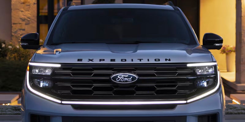 "Una Ford Expedition estacionada por una carretera con un fondo escénico, vista frontal."