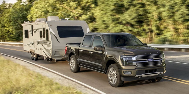 Un Ford F-150 circula por la autopista con un pequeño remolque enganchado.