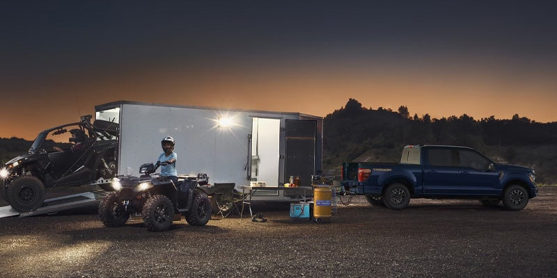 Una camioneta Ford F-150 estacionada junto a un contenedor en la oscuridad