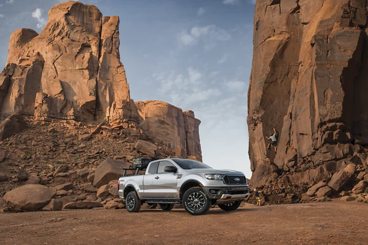 pickup truck in desert with rock climbers