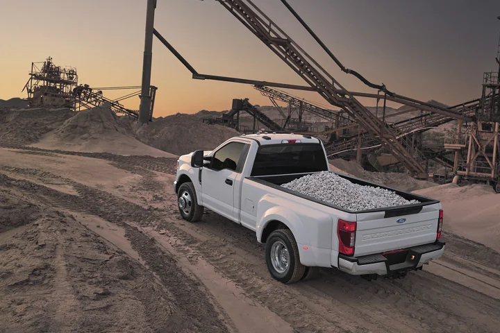 White work truck driving near a construction site